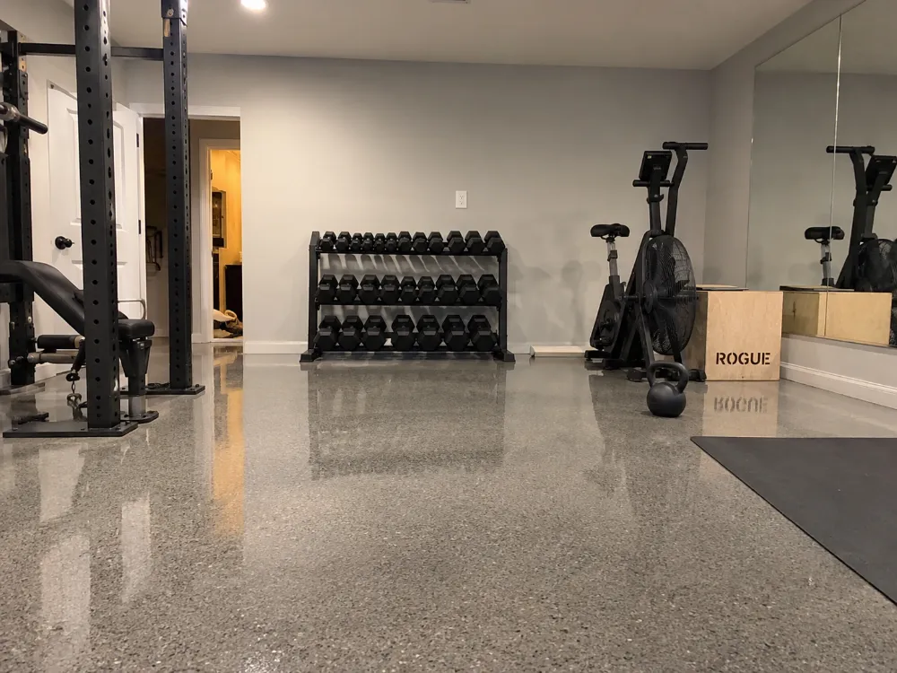 Home gym with epoxy-coated garage floor and weight equipment in Joplin, MO
